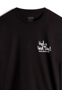 Sort bomulds T-shirt med korte ærmer, der har hvid tekst "Havde en god tid! VANS SIDEN 1966" på brystet. Klassisk pasform med rund halsudskæring.