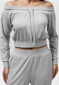 Szary, żebrowany, krótszy sweatshirt bez rękawów z dekoltem na sznurku; w zestawie z dopasowanymi spodniami z wysokim stanem z elastycznym pasem.