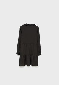 Robe noire à manches longues à volants avec col et poignets, vue de dos sur un fond gris clair uni.