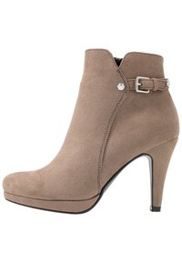 High-heeled ankle boot in taupe suede, featuring a side buckle accent and a smooth, sleek silhouette. Rounded toe and tapered heel design.