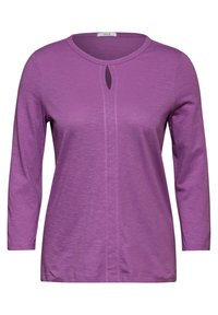 Lila Langarmoberteil mit rundem Ausschnitt und einem Schlüssellochdetail. Aus weichem, strukturiertem Stoff gefertigt und mit rosa Nähten entlang der Mitte.