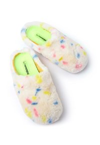 Zapatillas de casa esponjosas de color crema con salpicaduras multicolores de rosa, azul y amarillo. Textura suave, diseño de tipo slip-on y forro interior verde.