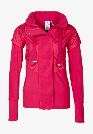 Veste pour femme de couleur rose vif à manches longues avec une superposition à manches courtes, col haut, fermeture éclair frontale et détails à cordon de serrage.