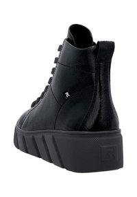 Baskets montantes noires avec une semelle épaisse texturée, une languette de tirage et une petite étiquette logo sur le côté, montrées de dos et de profil.