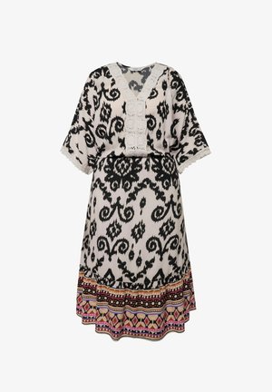 Robe à motifs noir et blanc avec un décolleté en V, des manches courtes et une finition en dentelle. Une bordure décorative colorée orne l'ourlet.