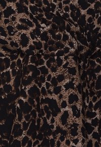 Hnědá a černá látka se vzorem leoparda, která má hladkou texturu a jemný drap.