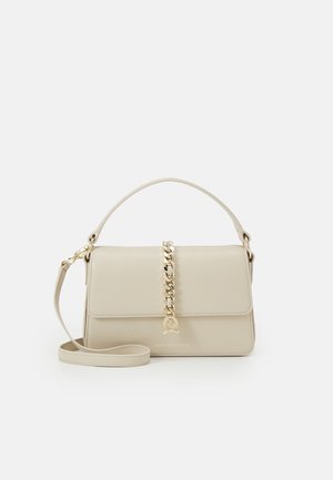 Beżowa prostokątna torebka z uchwytem u góry, złotym łańcuszkiem biegnącym wzdłuż środka oraz odpinanym paskiem na ramię, z widocznym logo z przodu.