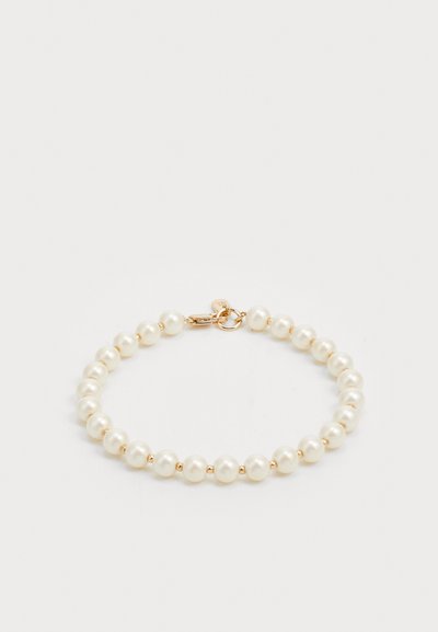 Bracelet en perles avec des perles rondes polies en blanc et fermoir doré. Texture lisse avec un design classique.