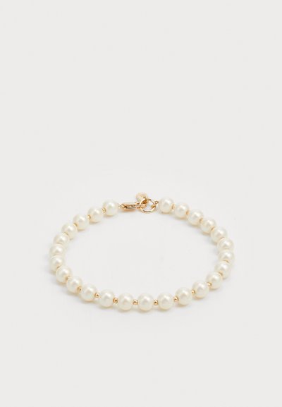 Bracelet en perles avec des perles rondes polies en blanc et fermoir doré. Texture lisse avec un design classique.