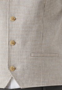 Light brown and cream checked blazer with three buttons, single chest pocket, and a subtle textured fabric. Features classic tailored design.