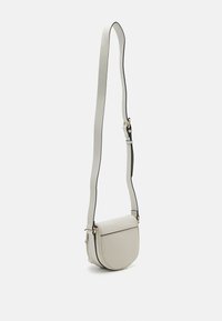 Bolso cruzado de cuero gris claro con forma redondeada, cierre de solapa plano y correa ajustable con borde negro y detalles en dorado.