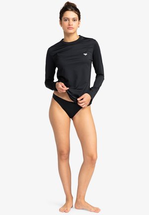 Black long-sleeve rash guard made of smooth, stretch fabric, featuring a small logo on the chest and a relaxed fit.
