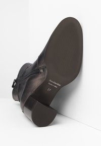 Stivaletto in pelle nera con tacco basso, cerniera laterale, finitura testurizzata e suola liscia con scanalature per una migliore aderenza. Taglia 37, made in Italy.