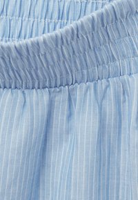 Lichtblauwe stof met subtiele witte strepen. Voorzien van een elastische, geplooide tailleband. Soepele textuur, casual en ademend uiterlijk.