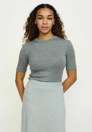 Graues, tailliertes Kurzarmoberteil mit Rundhalsausschnitt, kombiniert mit einem hellgrauen Rock. Das Material wirkt weich und dehnbar, ideal für die Freizeit.