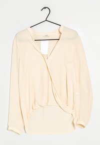 Blusa color pescato chiaro con scollo a V, maniche lunghe e design avvolgente. Realizzata in tessuto morbido con una vestibilità ampia e orlo curvo.