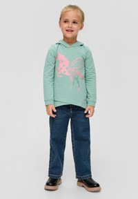 Miętowa bluza z kapturem z różowym graficznym motywem skrzydlatej klaczy, w zestawieniu z ciemnoniebieskimi dżinsami i czarnymi botkami za kostkę. Miękka tkanina, przednia kieszeń.