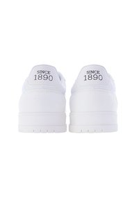 Le sneakers bianche presentano una parte superiore in pelle liscia con un tallone testurizzato e una suola in gomma scolpita. Sul retro è riportato in nero "SINCE 1890".