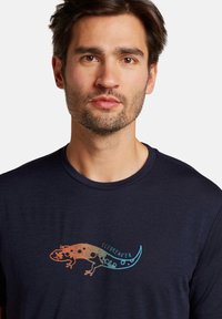 Navy blue short-sleeve t-shirt made of soft fabric, featuring a colorful lizard graphic with the word "ICEBREAKER" below it.