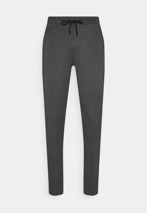 Gray sweatpants made of textured fabric, featuring a drawstring waist and tapered legs, with no visible patterns or hardware details.
