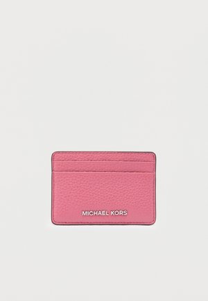 Portacarte in pelle rosa con finitura testurizzata, dotato di più scomparti per carte e logo "MICHAEL KORS" argentato sulla parte frontale.