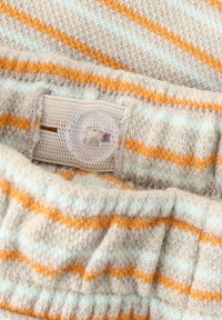 Tissu tricot léger avec des rayures horizontales en bleu pastel, orange et beige. Présente un bouton en plastique et une taille élastique.