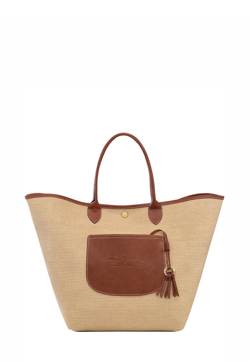 Tan woven tote bag with brown leather accents, large main compartment, and a front pocket featuring a decorative tassel.