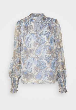 Blouse à manches longues à motif paisley floral, poignets froncés, col à nouer, aux couleurs douces bleu, beige et blanc sur tissu transparent.