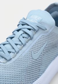 Vaaleansininen lenkkari, jossa on teksturoitu verkkomateriaali, litteät nauhat, pehmustettu kieli ja kumipohja. Sisältää hienovaraisen Nike-logon samansävyisenä.