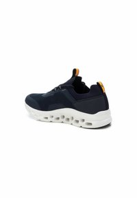Zapatilla deportiva de color navy con parte superior de malla, suela blanca acolchada con recortes y pequeño acento naranja en el talón.