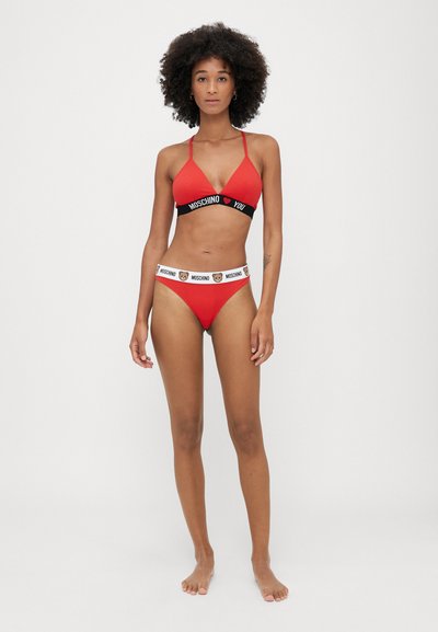 Red bikini set featuring a triangle bra with a black "MOSCHINO YOU" band and matching high-waisted bottom with logo accents. Smooth texture.