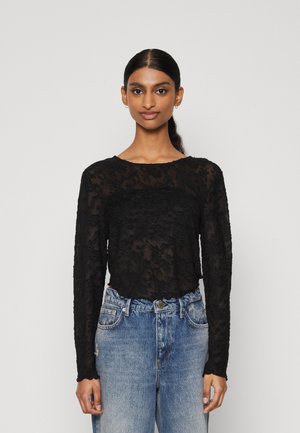 Zwarte kanten long-sleeve top met een bloemenpatroon, ronde halslijn en een comfortabele pasvorm, gecombineerd met hoge taille blauwe denim jeans.