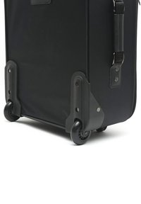 Black suitcase with hard plastic corners, durable fabric, dual wheels, and a top carry handle. Features metal accents and a zippered closure.