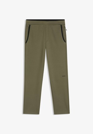 Joggers verde oliva in tessuto morbido, con tasche laterali nere con cerniera e fascia elastica nera in vita. Comprendono un dettaglio con logo discreto.
