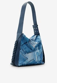 Torba na ramię w denimowym wzorze z niebieskimi skórzanymi akcentami, teksturowanym plecionym boku i metalowymi kropkami na pasku.