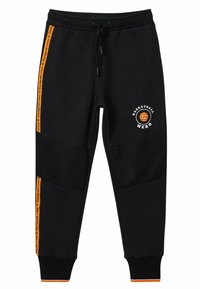 Zwarte sweatpants met mesh panelen, oranje zijstrepen met het label "Desigual Crew", en een "Basketball Hero" grafiek met een basketbalicoon.