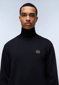 Sudadera negra de cuello alto hecha de mezcla de algodón. Cuenta con una insignia redonda en el pecho y una textura suave. Diseño simple y moderno.