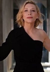 Svart axelbandslös klänning med en figursydd silhuett och slät textur. Minimalistisk design som framhäver rena linjer och en elegant form.