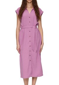 Sukienka zapinana na guziki w miękkim fioletowym materiale o teksturowanym wykończeniu. Posiada krótkie rękawy, wcięcie w talii z materiałowym paskiem oraz detale w postaci guzików z przodu.