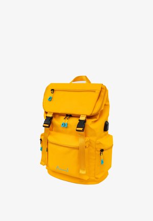 Yellow fabric backpack with a top flap, multiple zippered pockets, and blue zipper accents. Features adjustable straps and a sturdy handle.
