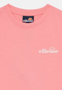 Šviesiai rožinė marškinė su apvaliu kaklu. Kairėje krūtinės pusėje yra baltas "ellesse" logotipas. Pagaminta iš minkštos, glotnios medvilnės audinio.