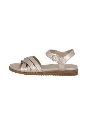 Beige leather sandal featuring three pleated straps, ankle strap with circular buckle, and a flat, textured sole for grip.