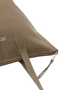 Bolso tote texturizado beige con una correa y cierre de cuero suave, que presenta un acento cosido y un logo discreto en la superficie.