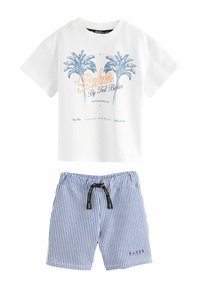 T-shirt bianca in cotone con grafica di una palma blu e testo; abbinata a pantaloni corti a righe blu e bianche con vita elastica e coulisse.