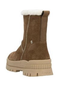 Bottines en suede brun avec un col en fausse fourrure blanche, des coutures contrastées et une semelle en caoutchouc épaisse de couleur crème. Présente un petit talon.