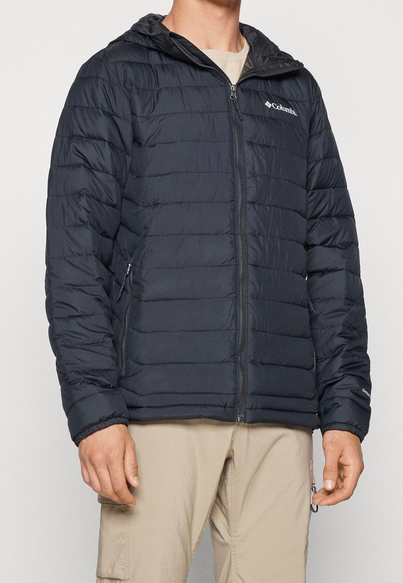 Czarna, wyściełana kurtka z suwakiem z przodu i kapturem. Posiada poziome przeszycia i boczne kieszenie, wykonana z lekkiego, wodoodpornego materiału.