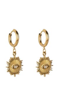 Gold hoop earrings with a sunburst design featuring an eye motif and a central clear crystal. Smooth texture, intricate detailing, dangle style.