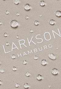 Béžová tkanina s vodními kapkami. "LARKSON HAMBURG" v bílé, tučné písmu ve spodní části. Texturovaný povrch s jemným vzorem tkaní.