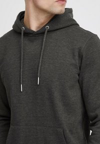 Donkergrijze hoodie van zacht, gestructureerd materiaal. Voorzien van een kangoeroezak, verstelbare trekkoorden en hardware in zilverkleurig metaal.