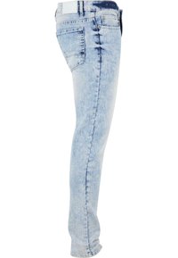 Jeans de mezclilla azul claro con corte slim, que cuentan con un diseño de cinco bolsillos y un lavado descolorido. Incluye detalles de costura y una cinturilla estándar.
